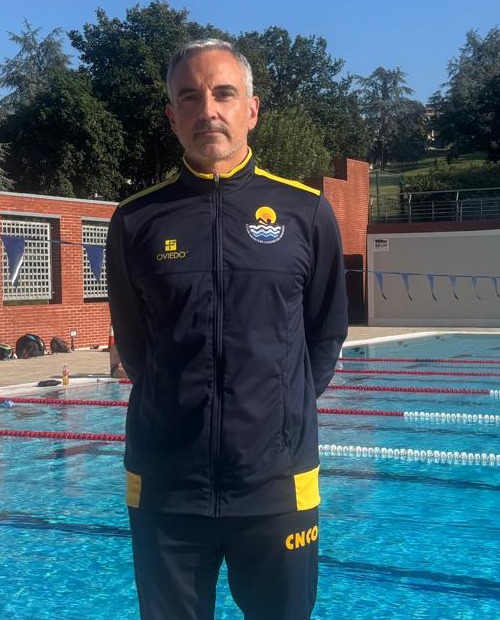 Antonio Oliveira, con la ropa del club, a pie de la piscina descubierta del CNCO, con el vaso de fondo.